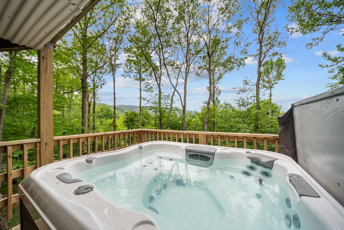 This image captures an outdoor hot tub set against lush greenery and distant hills, perfect for relaxing after a day on the slopes. The tranquil setting emphasizes the connection with nature and the appeal of mountain views, which are central to the roundhouse experience described in the section.